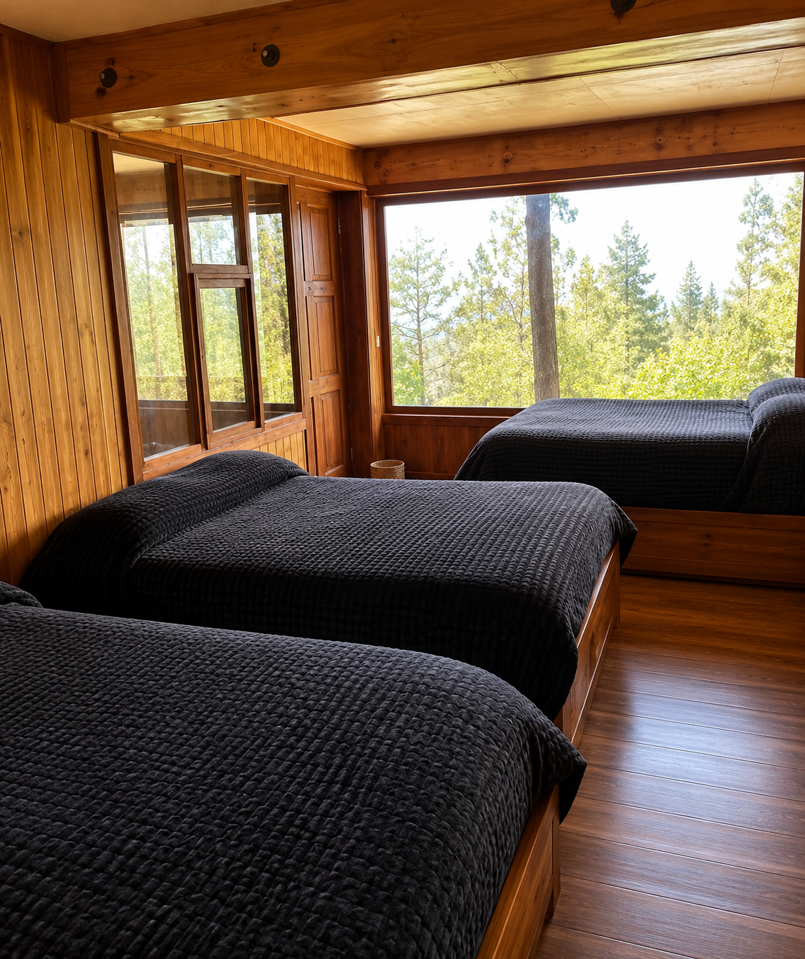 Habitación con camas y vista panorámica al bosque de pinos